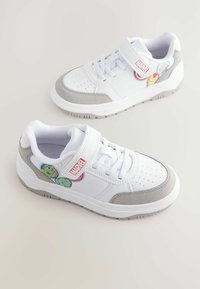 Zapatillas blancas con acentos de ante gris, puntera redondeada, parte superior perforada y parches de Marvel con personajes coloridos. Cinta de velcro y cordones.
