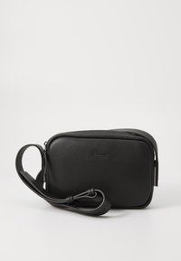Black leather crossbody bag with a textured finish, rectangular shape, adjustable strap, and a zipper closure. Logo embossed on the front.