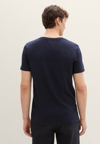 Mørkeblå T-skjorte med korte ermer, myk bomullsmateriale, rund hals, avslappet passform, glatt tekstur, har et enkelt og uforfalsket design.