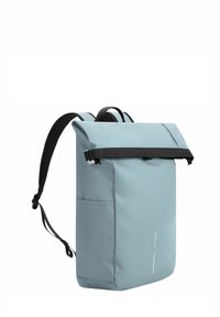 Ljusblå vattentät ryggsäck med rulltoppsstängning, svarta justerbara remmar, platt botten och en minimal vit logodetalj.