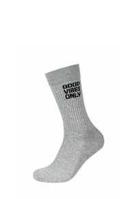 Calzino in cotone grigio con texture a costine e testo stampato in nero "GOOD VIBES ONLY" sul lato superiore. Lunghezza classica da crew.