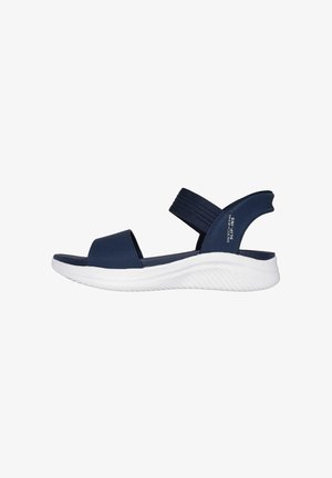 Sandal de color azul marino con correas elásticas anchas, diseño de punta abierta y suela blanca acolchada con estrías texturizadas para un mejor agarre.