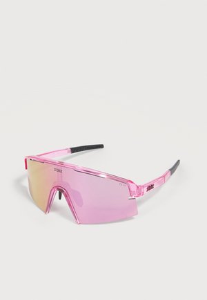 Ροζ σπορ γυαλιά ηλίου με έναν ενιαίο σκουρόχρωμο φακό και μαύρες άκρες στα μπράτσα που ακουμπούν σε μια λευκή επιφάνεια.