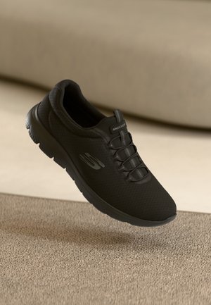 Schwarzer Sportschuh mit strukturiertem Mesh-Obermaterial, Schnürdesign und gepolsterter Sohle, mit Skechers-Logo an der Seite und auf der Zunge.