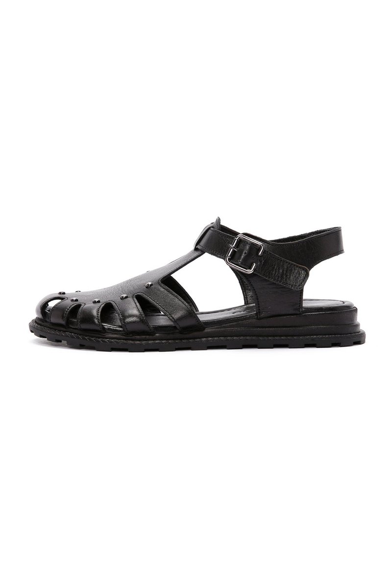 Sandali in pelle nera con design open-toe, lati traforati e fibbia laterale. La suola è strutturata per garantire aderenza e comfort.