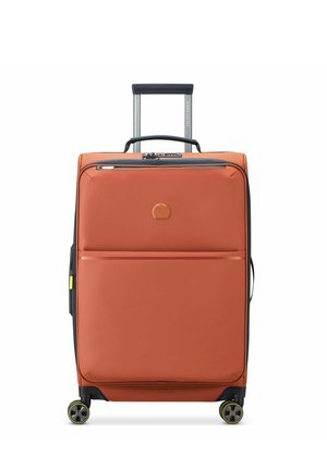 Hard-shell suitcase in orange with a textured finish, two front zip compartments, retractable handle, and yellow-accented wheels.