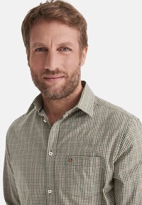 Grün-braun karierte Hemdbluse mit Kragen, einer Brusttasche, strukturiertem Stoff und kontrastierenden Knöpfen.