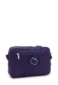 Bolso cruzado compacto de color púrpura oscuro con correa ajustable, bolsillo con cremallera en el frontal y detalles en cremallera plateada sobre un fondo blanco.