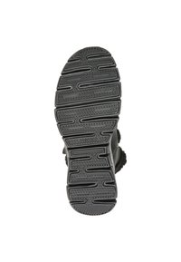 Suela de zapato negra con goma texturizada, que presenta surcos y crestas para tracción, y un tacón redondeado para estabilidad.