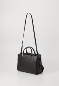 Sac à main en cuir noir avec deux poignées supérieures, une bandoulière réglable et des accents en métal doré. Dispose d'une poche zippée sur le côté.