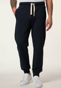 Marineblaue Jogginghosen aus weichem Stoff, mit Seitentaschen, gerippten Bündchen und einem kontrastierenden Kordelzug am Bund.