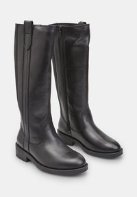 Térd feletti fekete bőr csizmák sima textúrával, oldalsó cipzáras záródással, kerek orral és alacsony, rakott sarokkal. Egyszerű dizájn, minták nélkül.