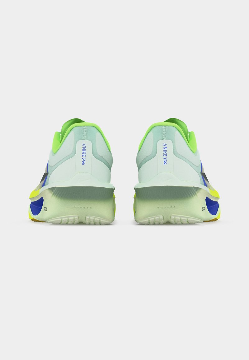 Paire de baskets de sport blanches et vert néon avec des accents bleus et jaunes, vues de dos sur un fond blanc.
