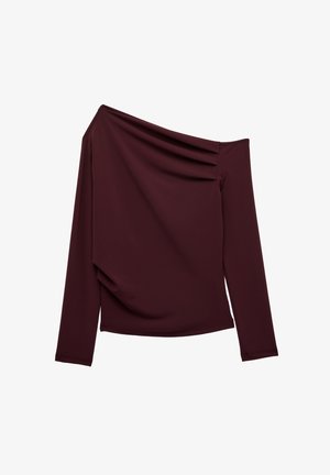 Asymmetrisk langærmet top i mørk burgunder med én skulder blottet og subtile draperingsdetaljer på venstre side foran.
