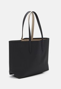 Zwarte tote bag met een gestructureerde buitenkant, gladde beige handvatten en een open ontwerp. Heeft een ruime binnenkant die ideaal is voor dagelijks gebruik.