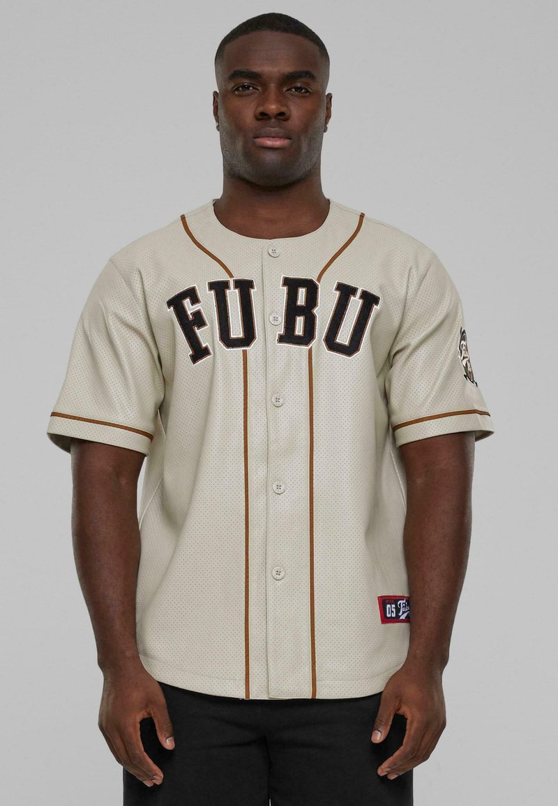 Maglietta da baseball in rete beige con lettere nere "FU BU", bordino marrone, maniche corte e una toppa con logo sulla manica sinistra.