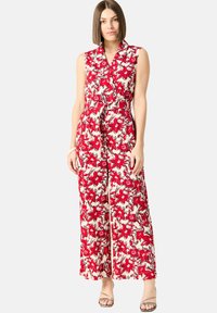 Blommig maxiklänning med krage, röd och vit mönstring, bälte i midjan, ärmlös design och flödande tyg.