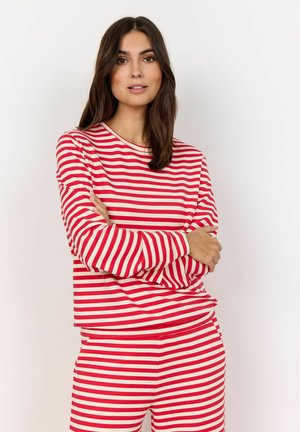 Haut à manches longues rayé rouge et blanc avec un pantalon assorti, présentant une coupe décontractée et une texture de tissu douce. Encolure ronde simple.
