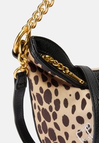 Borsa a mano in pelle nera con fodera in stampa leopardata, dotata di una tracolla in catena dorata e di una cerniera, che mette in risalto un design strutturato e curvo.
