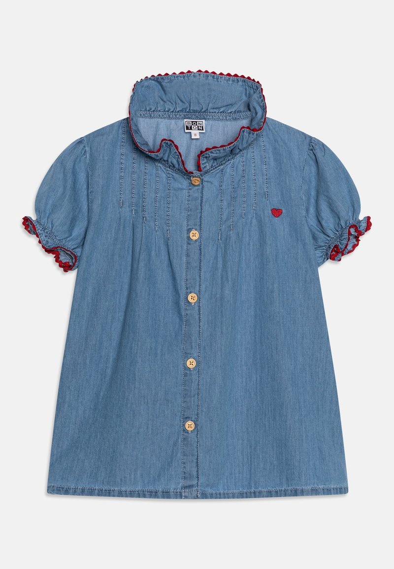Robe en denim bleu à manches courtes avec boutons en bois, col volanté et poignets bordés de rouge, avec un petit cœur rouge brodé sur la poitrine.