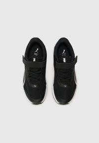 Chaussures de sport noires avec une tige en mesh, semelle antidérapante et une sangle Velcro au milieu du pied. Présente des accents blancs et un col rembourré.