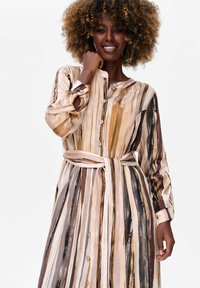 Gestrikt, langemouwen jurk in aardetinten van beige, bruin en zwart, met een knopenfront en een bijpassende riem in de taille.