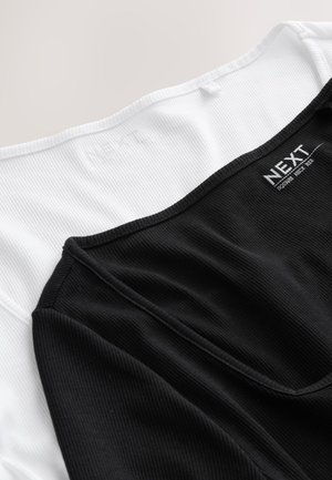 Top fără mâneci alb-negru cu textură nervurată, având un decolteu pătrat și cu eticheta "NEXT" în interiorul gulerului.