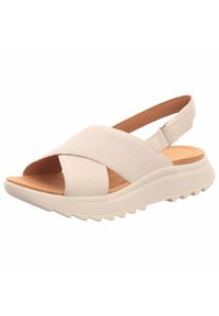 Sandale beige à enfiler avec des sangles croisées en matériau texturé, semelle intérieure rembourrée et semelle légère avec un motif de vagues.