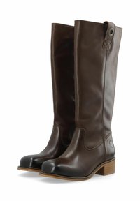 Rjave usnjene škornje do kolen z zaobljenim nosom, nasprotnim črnim pokrovčkom za nos, zloženim peto in dekorativnim detajlom stranskega gumba.