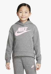 Grå hettegenser med en rosa Nike-logo, med snøring i hetten, lange ermer og en forlomme. Kombinert med matchende grå joggebukser.