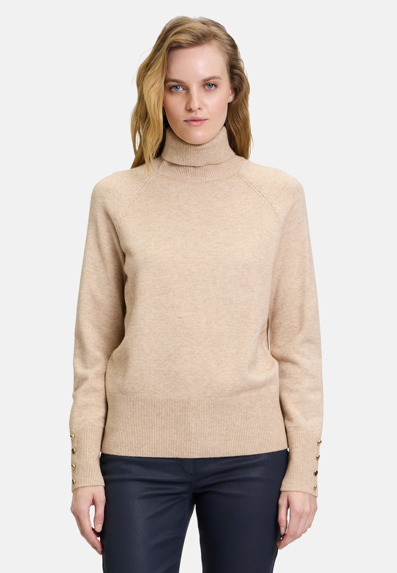 Beige Rollkragenpullover mit geripptem Saum und Bündchen, ausgestattet mit goldfarbenen Knopfdetails an den Ärmeln; gefertigt aus weichem, strukturiertem Material.