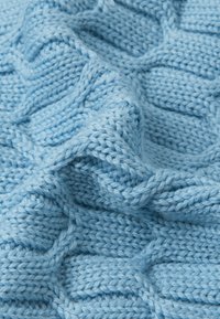 Tessuto lavorato a maglia di un blu chiaro con un motivo a trecce dalle texture. Filato morbido e spesso crea un aspetto accogliente. Punto e struttura visibili in tutto il tessuto.