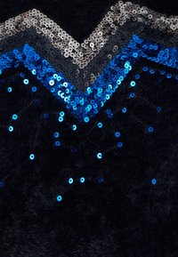 Schwarzer Stoff mit einer weichen, samtigen Textur, verziert mit mehrfarbigen Pailletten in Blau-, Silber- und Schwarztönen, die in einem Zickzackmuster angeordnet sind.