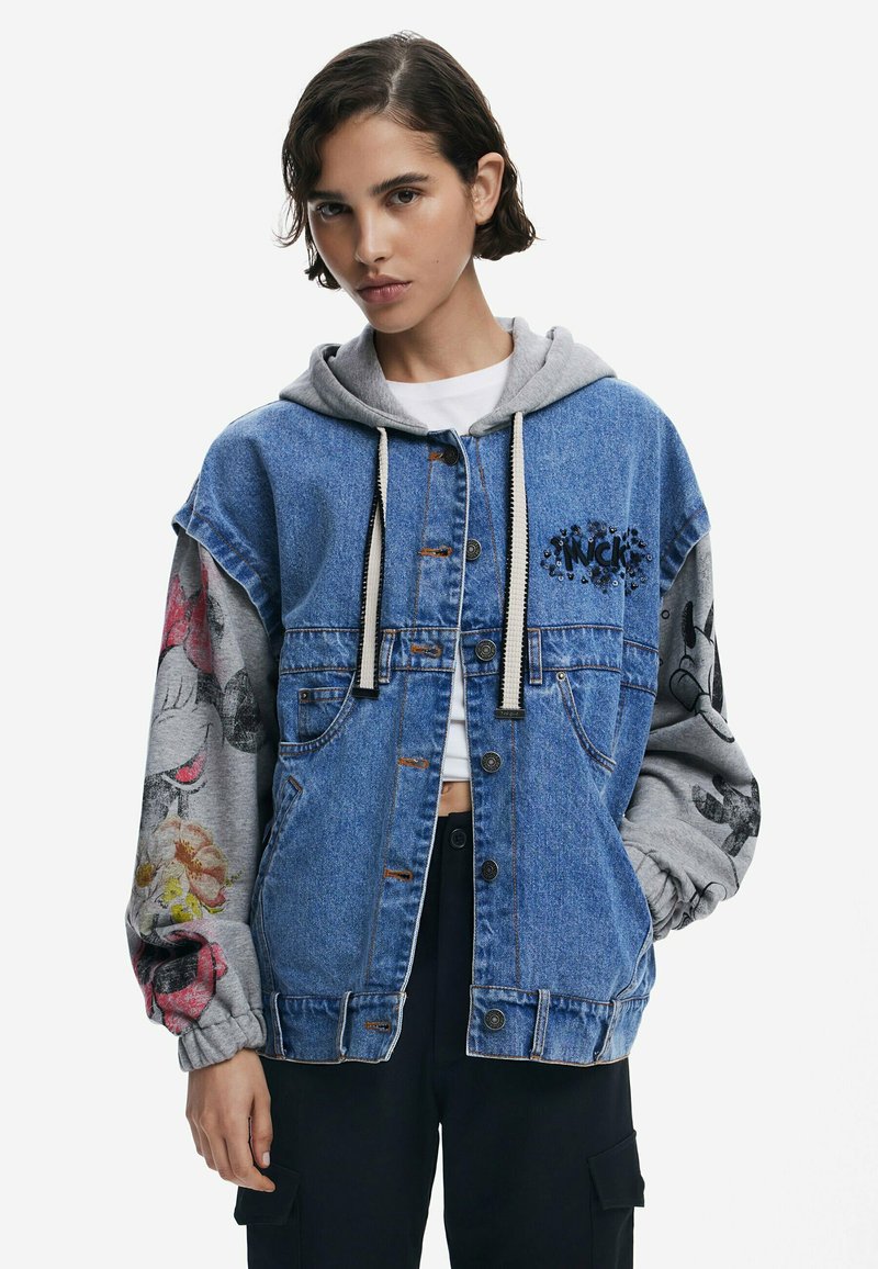 Jeansjacke mit grauem Kapuzen, versehen mit bunten Grafiken an den Ärmeln. Knopfverschluss, Fronttaschen und dekorative Stickereien auf der Brust.