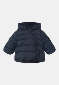 Námorně modrá pufová bunda pro batolata s kapucí, malými černými tečkami a volánkovým lemem vpředu na bílém pozadí.