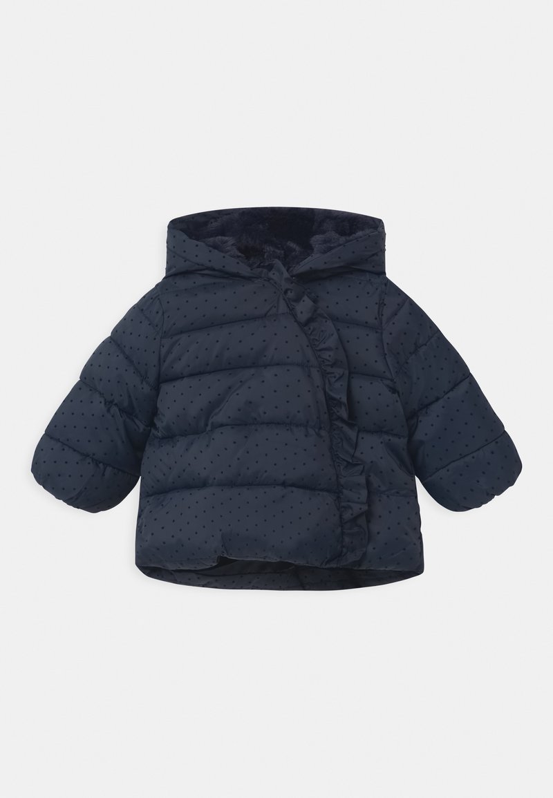 Námorně modrá pufová bunda pro batolata s kapucí, malými černými tečkami a volánkovým lemem vpředu na bílém pozadí.