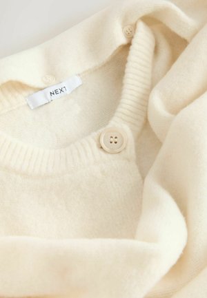 Crème kleurige gebreide trui met een ronde halslijn, voorzien van ribbelaccenten en een knoopsluiting. Etiket leest "NEXT." Zachte, gestructureerde stof.