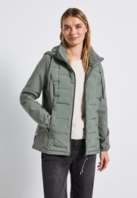 Lichtgroene pufferjack met capuchon, voorzien van elastische manchetten, ritszakken, een gladde textuur en verstelbare koorden in de taille.
