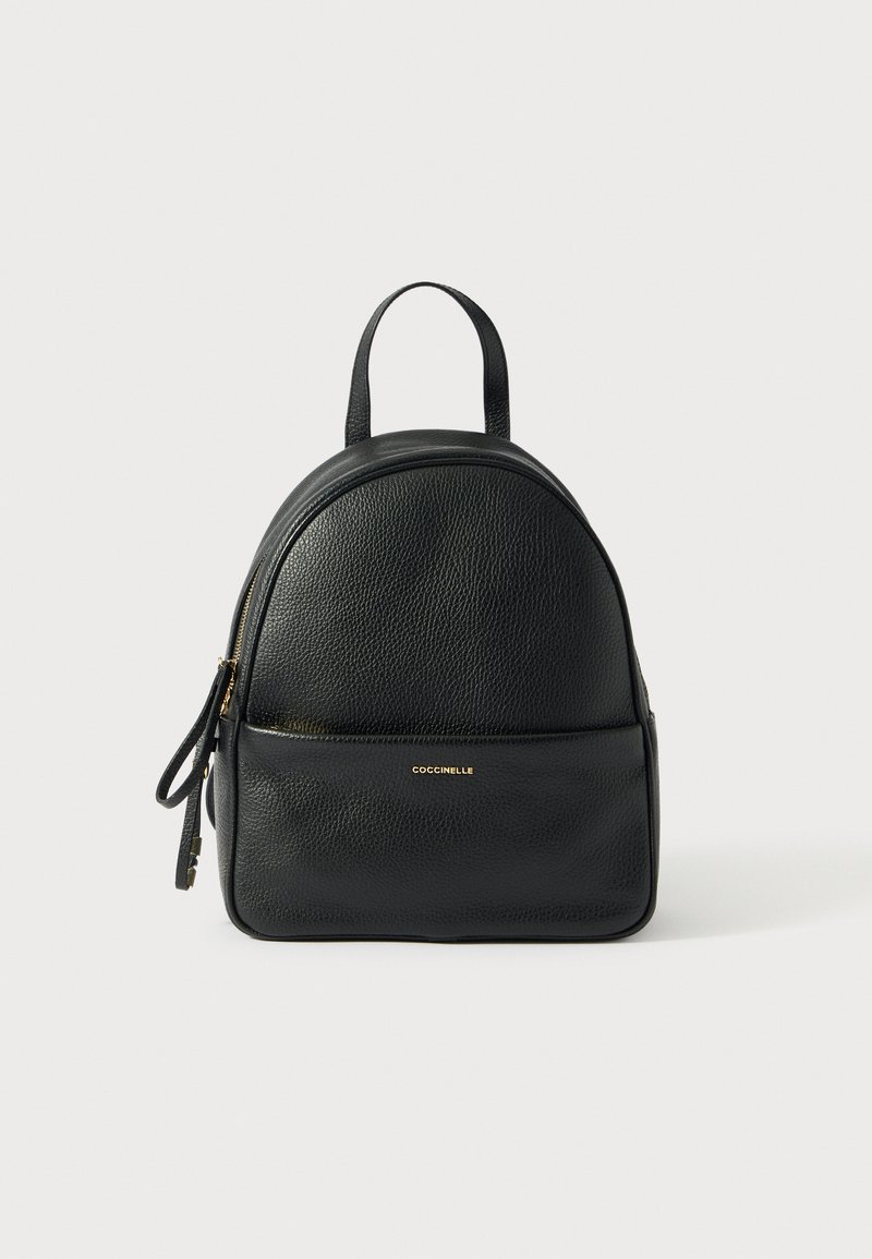 Mochila negra de cuero con un diseño redondeado, textura granulada, cierre de cremallera, asa superior y un bolsillo frontal con una marca dorada.