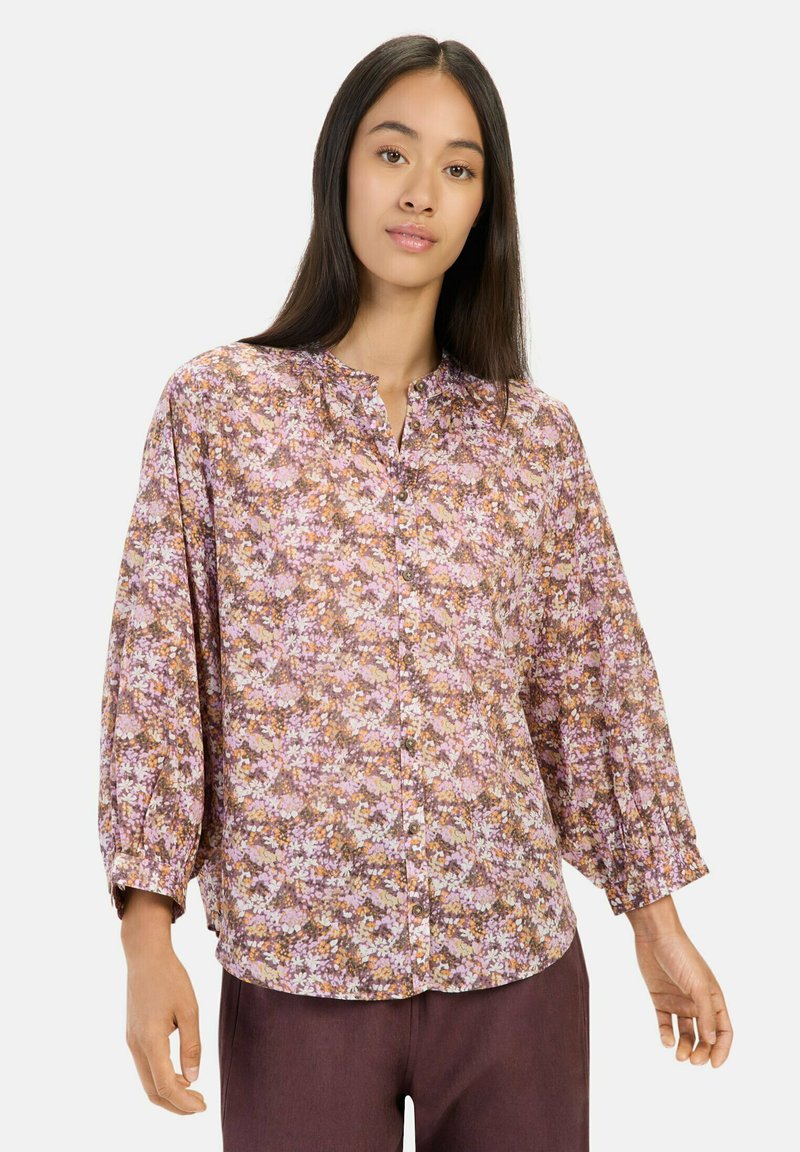 Langærmet bluse i let materiale med et lilla, pink og orange blomsterprint. Knapfront med afslappet pasform og samlet ærmer.