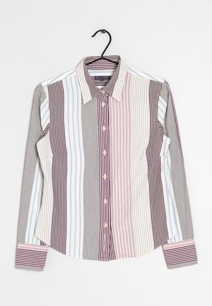 Chemise à manches longues avec boutons, rayures verticales marron, beige, rose et bleu clair, suspendue sur un cintre noir sur fond blanc.