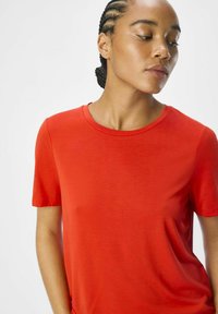 Rød kortærmet t-shirt lavet af blødt stof, med rund halsudskæring og afslappet pasform, med glat tekstur og ingen synlige mønstre.
