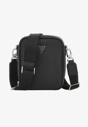 Sac bandoulière carré noir avec une sangle large réglable, des fermetures éclair argentées et un petit logo triangulaire Guess à l'avant.