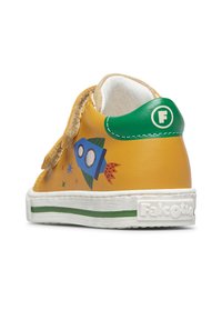 Sneaker per bimbi gialle e verdi con un design a razzo blu, cinturino in velcro e suola bianca con striscia verde e marchio "Falcotto".