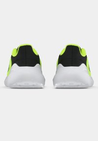 Sorte og neongrønne treningssko med polstret krage og hvit såle, med en teksturert overdel og en glatt, avrundet form.