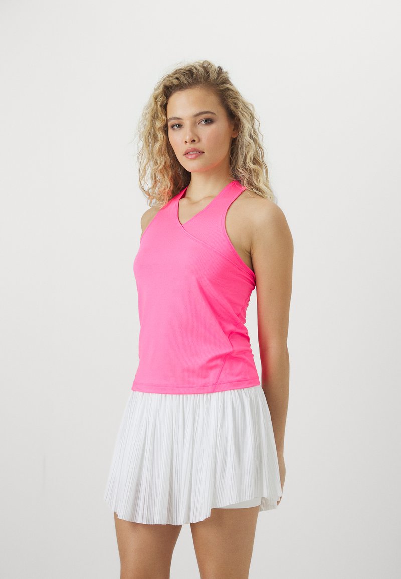 Rosa trenings tank topp med kryssryggdesign, kombinert med en plisséert hvit skort, som har lett og pustende stoff.