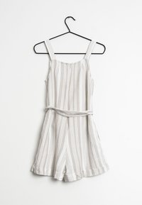 Romper rayé en beige clair et blanc. Doté de fines bretelles, d'une taille cintrée et de shorts larges avec une coupe décontractée. En matériau coton.