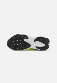 Suela de goma negra con patrones en forma de ola, entresuela blanca y un toque de color brillante en los bordes. Superficie duradera y texturizada para mayor tracción.