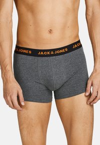 Graue Baumwollboxershorts mit einem schwarzen Bund, der ein oranges "JACK & JONES"-Logo trägt. Das Design ist eng anliegend und hat keine sichtbaren Muster oder Metallteile.