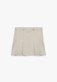 Geplooide beige rok van textuurstof; heeft een tailleband met riemlussen en een verborgen rits aan de achterkant.